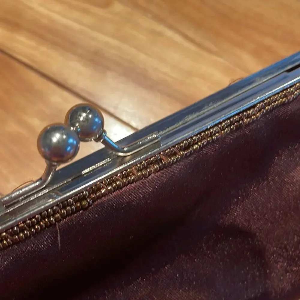 Satiny chocolate brown crystal and bead accent ball snap closure clutch.